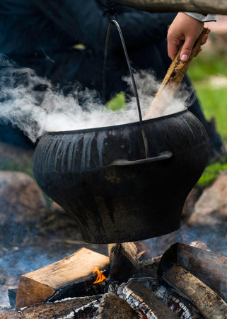 Big black cooking pot on fire outdoorsの写真素材