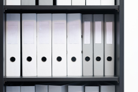 Blank blind folders with files in the shelf. Archival, stacks of documents in the book at the office with space for textの写真素材