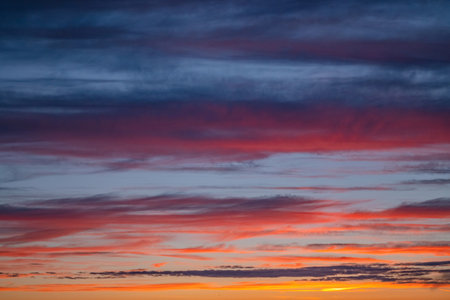 Dramatic sunset sky panorama with burning colourful clouds background. Idyllic cloudscape backdrop...