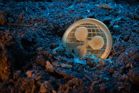Mining crypto currency - Ripple coin. Online money coin in the dirt ground. Digital currency, block chain market, online businessの写真素材