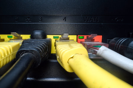 Multicolored network cables inserted in the router panel on a dark background. Internet connection,...