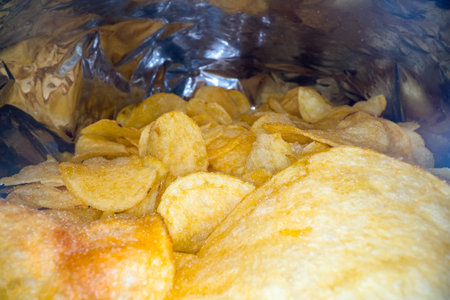 Inside the potato chips bag. Opened pack of original taste delicious potato crisps. Fast food and...