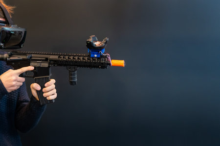 Teenager wearing VR goggles and playing shooting game. Virtual reality shooter game with gun 3D...