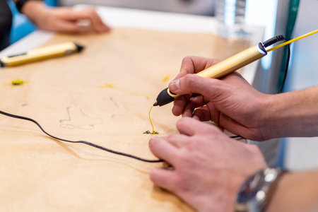 Person creating with 3D handle pen. Teenager using modern printing pen. Creative craft class