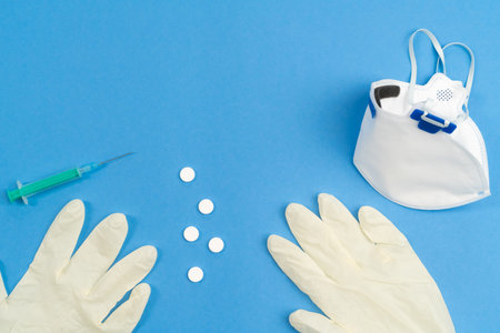 Still life of medical objects - flu vaccine, pills and needle on blue background. Corona virus,...