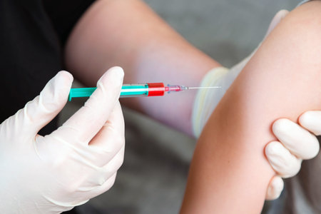 Close up of nurse hands giving flu vaccine into the shoulder of patient. Doctor vaccinating infected...