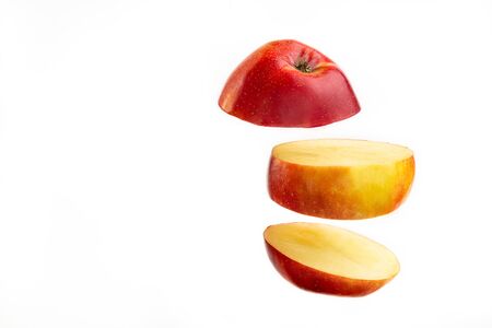 Sliced apple floating on white background. Fruit slice falling on bright backdrop.の写真素材