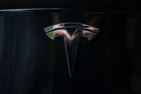 Prague, Czech Republic - June 2020: Tesla motors car badge logo dark background. Modern electric vehicle manufacturer.のeditorial素材