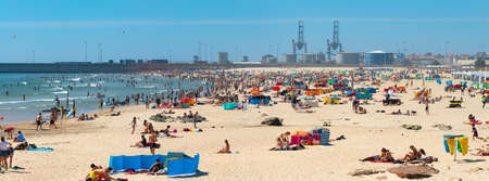 Porto, Portugal - June 2019: People sunbathing on Matosinhos beach by Atlantic ocean on a sunny day. Families enjoying summer on the sandy shore of Portugal.のeditorial素材