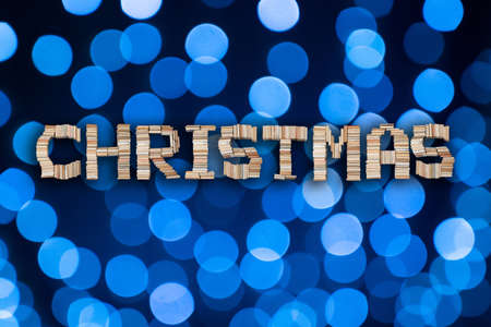 Christmas text on abstract blue bokeh balls background. Holiday letters on festive backgroundの写真素材