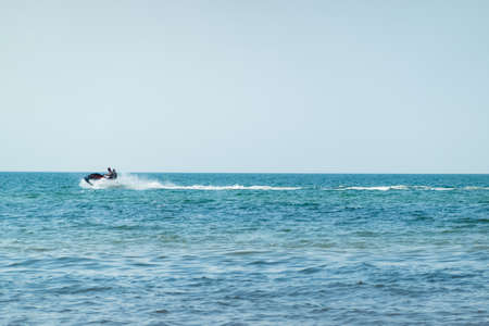 People enjoying water jet ski in a blue sea on a sunny day. Tropical holiday water activities.の写真素材