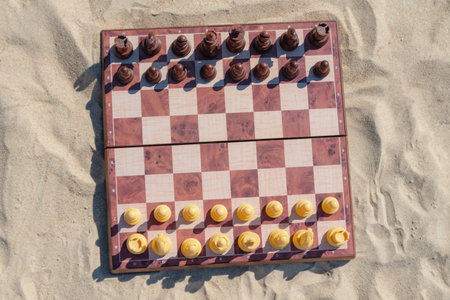 Chess play on the board at the beach. Chessboard on the sand on a sunny day.