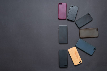 Pile of multicolored plastic back covers for mobile phone on black background. Choice of smart phone...