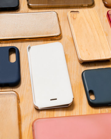 Pile of multicolored plastic back covers for mobile phone. Choice of smart phone protector accessories on wooden background. A lot of silicone phone backs or skins next to each other, patternの写真素材