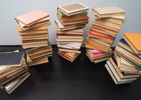Big stack of books on the table. Studying before the exam. Pile of vintage books. Concept of education and studyingの写真素材