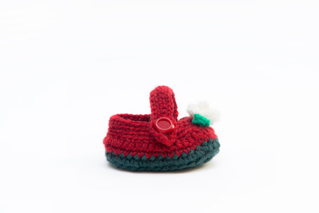 Handmade knitted shoes for small children. Adorable newborn baby shoes isolated on white background.の写真素材