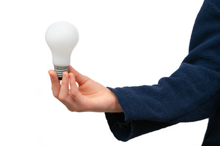 Close up of hand holding light bulb on white background.の写真素材