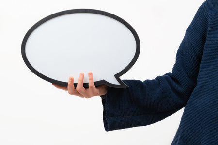 Close up of person holding blank speech bubble on whiteの写真素材