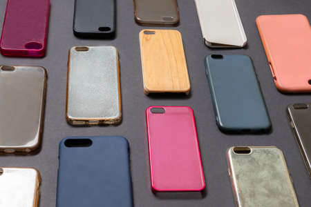 Pile of multicolored plastic back covers for mobile phone. Choice of smart phone protector accessories on black background. A lot of silicone phone backs or skins next to each otherの写真素材