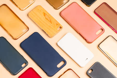 Pile of multicolored plastic back covers for mobile phone. Choice of smart phone protector accessories on neutral background. A lot of silicone phone backs or skins next to each otherの写真素材