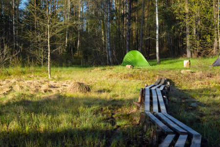 Camping tent set up near the lake in the forest. Relaxing in a camp site outdoors.の写真素材
