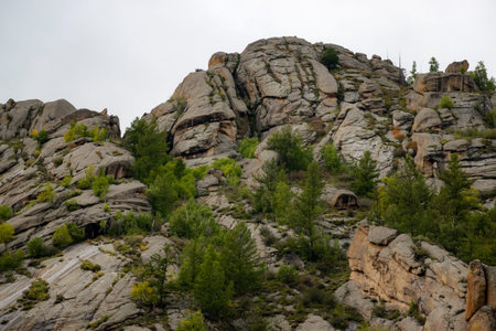 Rocky foothill with the clouds and blue sky in the background. Rock mountain in Mongolia on a cloudy...