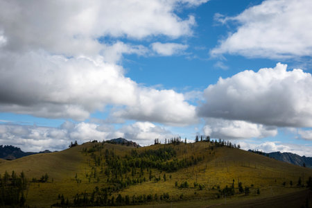 Beautiful mountain foothill, clouds and blue sky in the background. Mongolian mountain landscape on a cloudy day.の写真素材