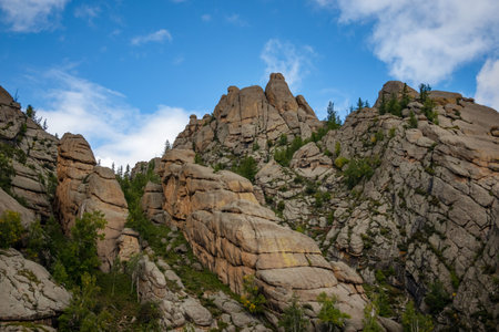 Rocky foothill with the clouds and blue sky in the background. Rock mountain in Mongolia on a cloudy day.の写真素材