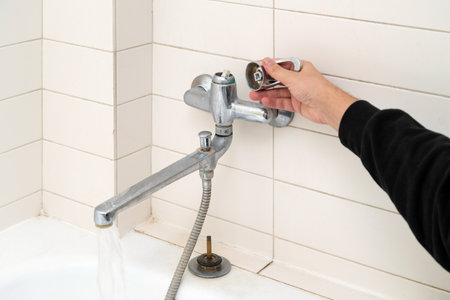 Leaking shower faucet. Broken bathtub handle. Emergency repairの写真素材