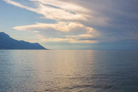 Dusk at Lake Geneva, rain cloud opposite subtle glowing sunset, amazing cloudscape
