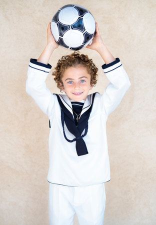 Positive religious communion boy with book standing on pink backgroundの写真素材