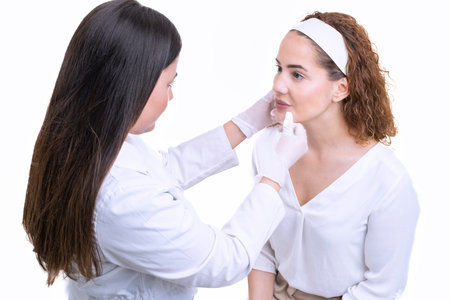 Crop beautician painting face client in aesthetic clinicの写真素材