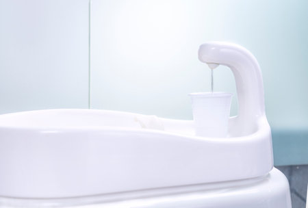 pouring water into cup in dental clinicの写真素材