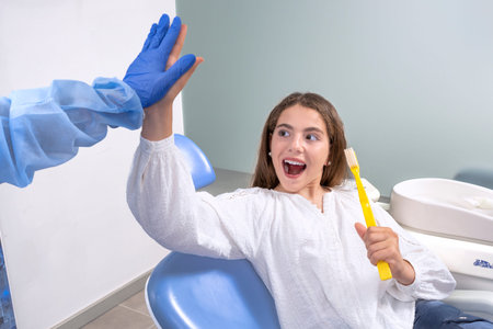Calm girl with opened mouth during teeth treatment in dentist clinic happyの写真素材