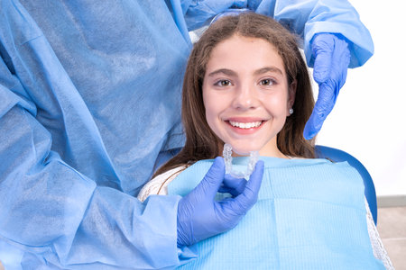 girl with opened mouth during teeth treatment in dentist clinic with invisalignの写真素材