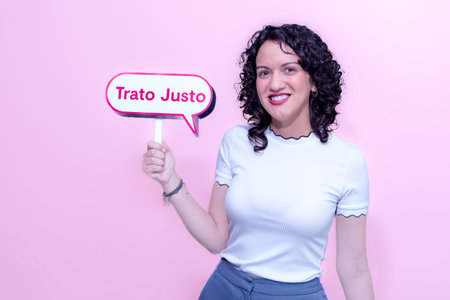 woman with white sweater over pink background smiling with fair treatment signal