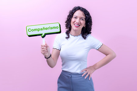 woman wearing white sweater over pink background smiling with fellowship signalの写真素材