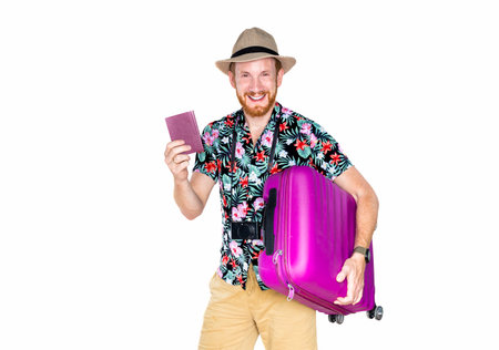 Funny young traveler tourist man in summer clothes hat hold suitcase passport ticket looking aside isolated white background. Passenger traveling on weekend. Air flight journey concept.の写真素材