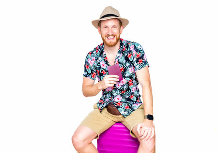 tourist man in summer clothes holding suitcase passport on white background.の写真素材