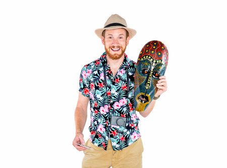 Cheerful man with suitcase and straw hat isolated on white background on vacations with a maskの写真素材