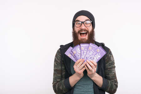 Moldova/ Chisinau- 3/ january/ 2020 -Photo of happy young bearded man holding MILKA chocolateのeditorial素材