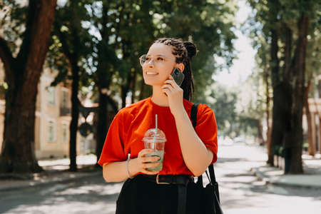A photo of a young woman talking to her phoneの写真素材