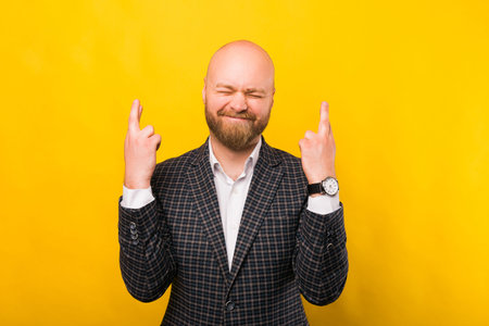 A photo of a businessman holding his fingers crossedの写真素材