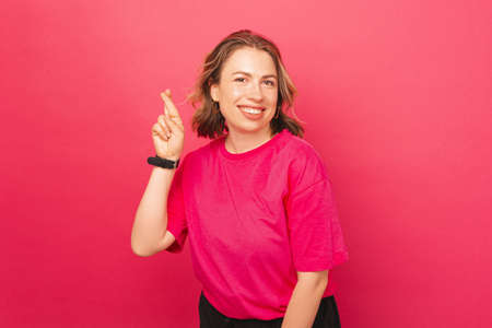 A piicture of a young woman holding her fingers crossedの写真素材