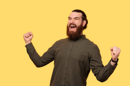 An excited bearded man screaming of happiness