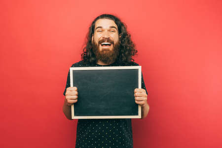 A picture of a bearded holding a chalkboard smiling at the cameraの写真素材