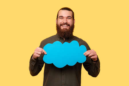 A photo of a young man holding a blue speech bubbleの写真素材