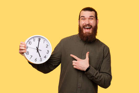 A picture of a man holding a white clockの写真素材