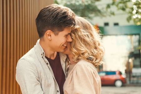 Content couple of a smiling man embracing lovely blonde woman in the street.の写真素材
