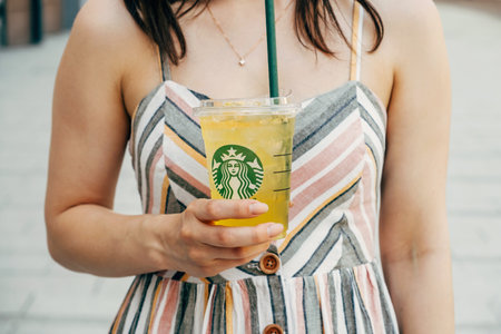 Hungary, Budapest. 16 JUNE 2022. Faceless photo of a young woman holding a fresh lemonade made by Starbucks.のeditorial素材